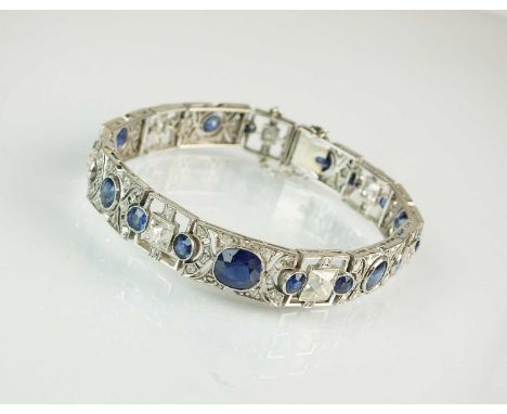 An Art Deco diamond and sapphire bracelet, designed as seven graduated openwork panel links set with a central oval or round 