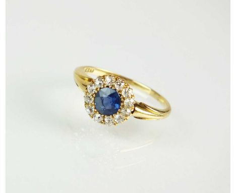 A late 19th century sapphire and diamond cluster ring, designed as a central round mixed cut sapphire claw set within a borde