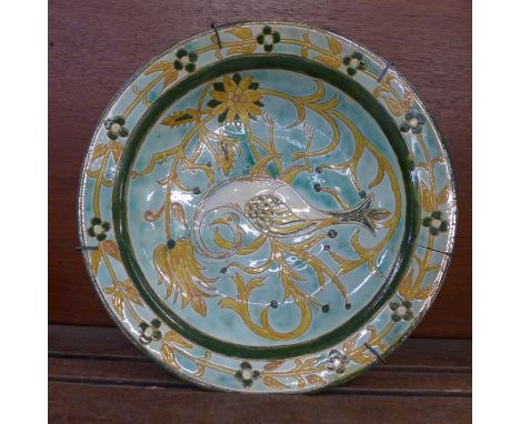 A c1900 Della Robbia shallow bowl decorated with a stylised swan, cracked and with firing crack on the rim, 29cm