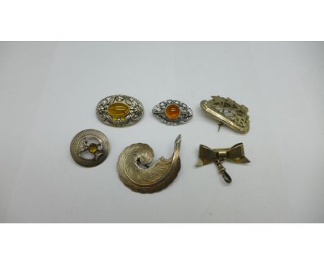 Six brooches including a silver thistle brooch, Victorian harp brooch and a silver bow hanger brooch 