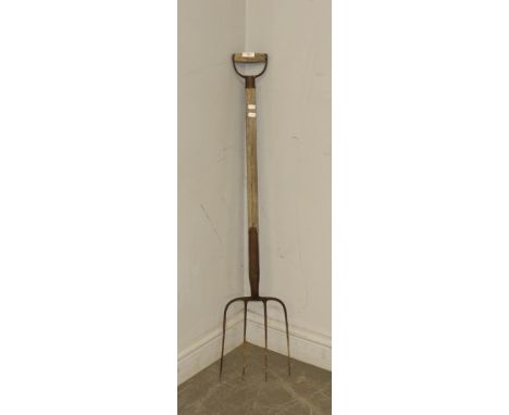 A vintage four tine pitch or manure fork, 108cm weathered, wear to handle, a degree of corrosion throughout.