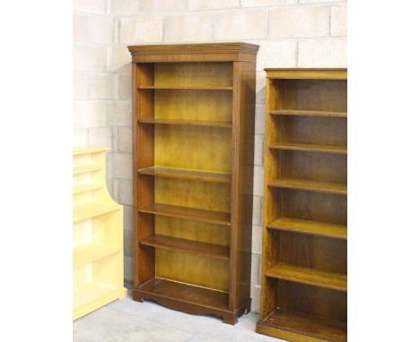 A tall reproduction mahogany bookcase, with moulded and dentil carved cornice above adjustable shelving, on bracket feet 201c