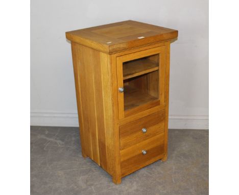 A modern light oak music/media cabinet, with glazed and hinged door over two drawers 92cm x 50cm x 46cm good used condition.