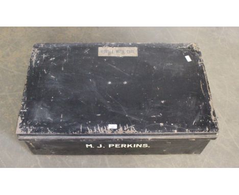 A large black painted metal trunk, named M.J Perkins 91.5cm some denting and paint losses.
