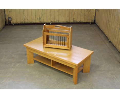 A modern light oak effect coffee table 38cm x 110cm x 50cm together with a hard wood magazine rack. Wear to coffee table with