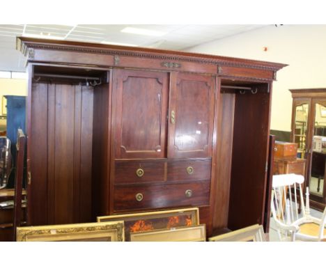 An Edwardian figured mahogany Gentleman's wardrobe, having a moulded cornice and sectioned frieze with gilt metal mounts over