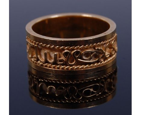 A Middle Eastern yellow metal band ring, decorated with hieroglyphics, tests as approx 18ct, 7.2g, size M