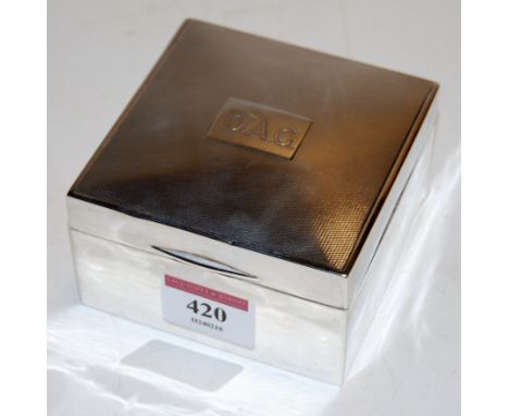 A George VI silver table cigarette box of square form having engine turned lid and cartouche initialled DAG