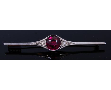 An Art Deco yellow gold and platinum faced bar brooch, centre set with a round cut amethyst weighing approx 2.5ct, flanked to