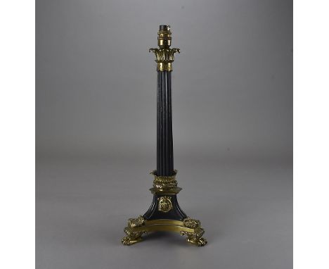 An Empire ormolu candle stick, with fluted column with leaf capital, over an Egyptian influence tripartite base to paw feet, 