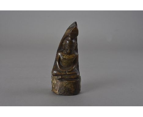A 19th century Siamese or Laotian rhino horn Buddha, seated in the Dhyana Mudra, parcel gilt to the chest area 16 cm H Some d