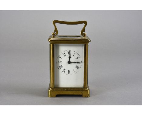 A mid 20th century brass carriage clock, having black Roman numerals to white enamel face, including key, 11cm H, together wi