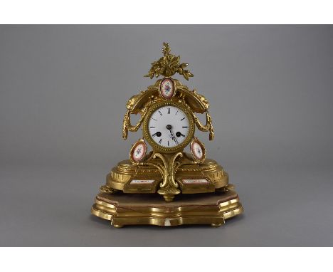 A 19th century French Sevres gilt mantle clock, the gilt painted clock with white enamel dial with black Roman numerals, with