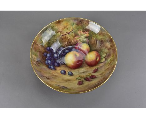 A Royal Worcester fruit painted bowl, with grapes, peach, apples and raspberries, the outside with gilt decoration to a black