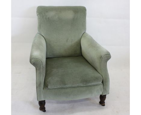 A late 19th century Howard style armchair, in green upholstery and turned supports on brass and ceramic castors 77 cm long x 