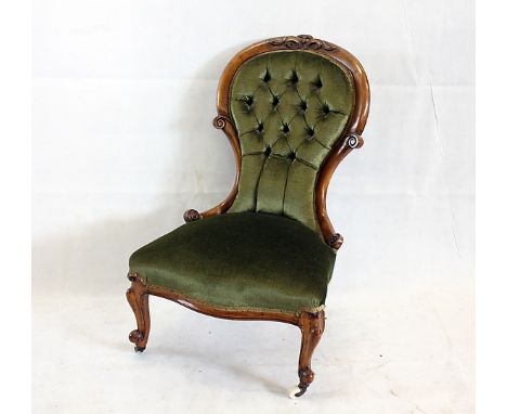 A Victorian spoon back walnut chair, with green button back upholstery and ceramic casters 