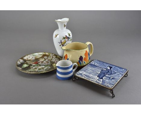 A Clarice Cliff Autumn Crocus Pattern jug, together with a Wedgwood blue and white tile topped teapot stand for November, a T