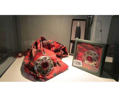 A tartan scarf with attached brooch, another brooch and a boxed Sgian Dubh.