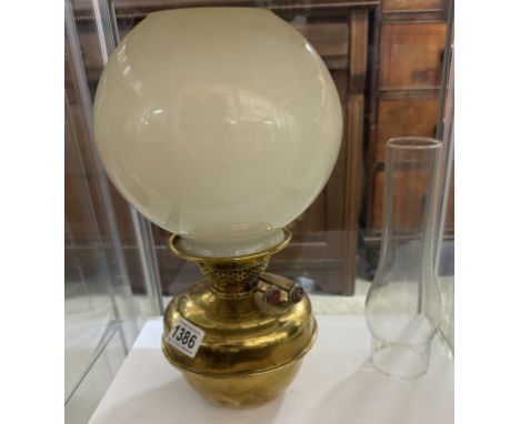 A brass oil lamp font with shade and chimney.