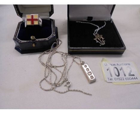 A silver gent's ring featuring a cross and two silver pendants.