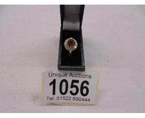 A diamond and citrine cluster ring in 18ct gold, size J, 3.3 grams.Fine scratches to top edge of citrine, otherwise ring is i