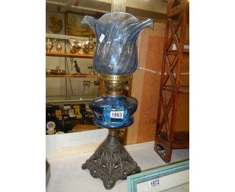 An oil lamp with blue glass font and shade, COLLECT ONLY.Shade has a crack and chips to bottom rim. Font has no visible damag