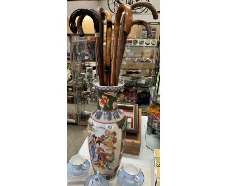 A large Chinese vase/stick stand and a quantity of walking sticks