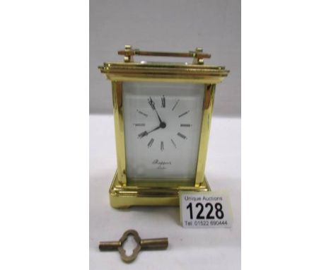A brass chiming carriage clock on bells marked Rapport London, in working order.