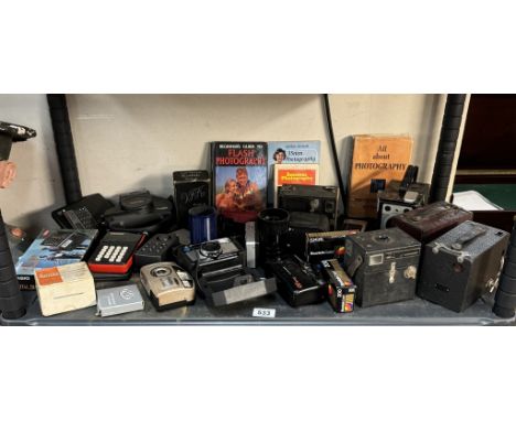 A large shelf of vintage cameras etc