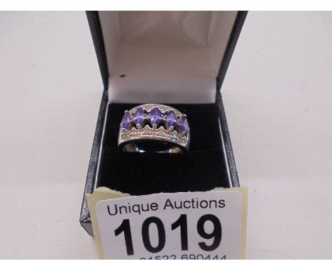 A silver (925) ring set with five amethyst coloured stones, size L.