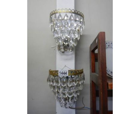 A pair of chandelier style wall lights with glass droppers.