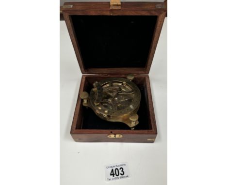 A brass compass in a wooden box