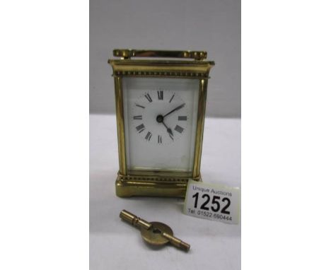 A brass carriage clock in working order and with key.