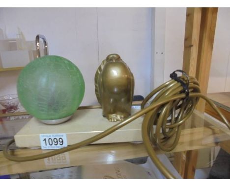 An art deco lamp on a marble base with a dove and a green globe shade.