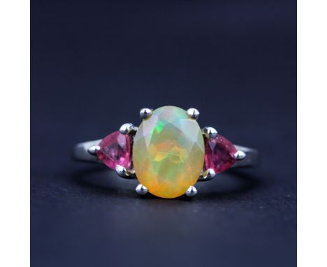 A 925 silver ring set with an oval cut opal and ruby set shoulders, (L.5).