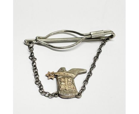 A vintage tie clip with sterling silver and gilt cowboy boot.