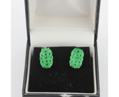 A pair of yellow metal (tested minimum 9ct gold) carved jade stud earrings, L. 1.5cm.