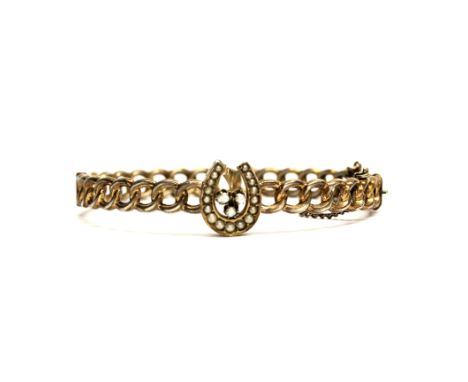 A Victorian gilt white metal (tested silver) horse shoe and seed pearl bangle.