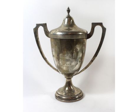 A George V silver twin handled trophyOf tapering form with twin handles and finial detail lid, inscribed 'Culceth Hall Cricke