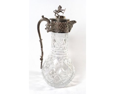 A silver-plated mounted decanterThe decanter with foliate embossed hinged lid, lion and shield finial and loop handle, height