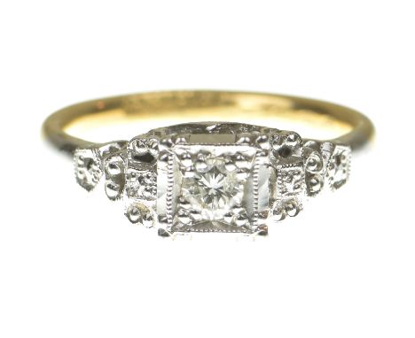 A diamond ring
Centering a round brilliant cut diamond, within a square surround flanked by pierced shoulders, to a shank sta