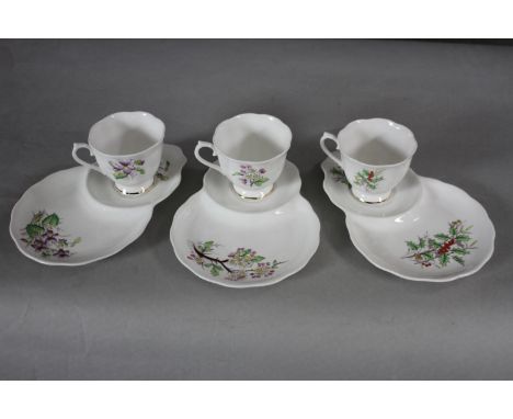 Three Royal Albert fine china hand painted cups and unusual saucers with integral plates each with a flower of the month. Vio