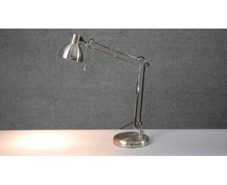 A brushed chrome anglepoise style adjustable desk lamp on circular base. H.34 W.36cm 