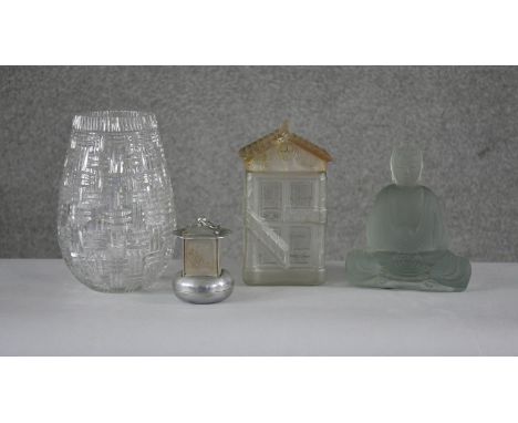 A collection of glassware. Including a cut crystal vase, a frosted glass cookie jar in the form of a house, a frosted glass b