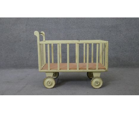 A vintage painted child's toy trolley or doll's pram. H.58 W.75 D.34 cm 