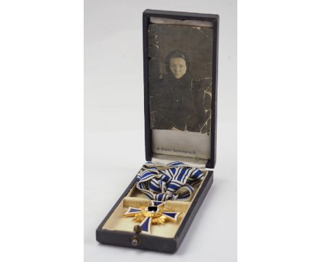Ehrenkreuz der Deutschen Mutter, in Gold, im Etui.Buntmetall vergoldet, teilweise emailliert, Medaillon separat aufgelegt, am