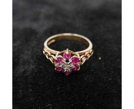 A boxed 9ct yellow gold diamond and ruby flower-cluster ring to pierced heart-shaped shoulders, Size: P 1/2, 2.8g. 