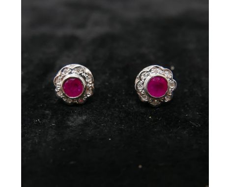 A boxed pair of 9ct yellow and white gold ruby and diamond cluster earrings. Cluster dia: 1cm. Gross: 2.1g. 