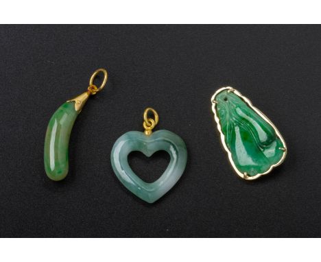 A GROUP OF THREE JADE PENDANTS
Comprising: a heart-shaped example with gold coloured bale; one example carved with gourds, in