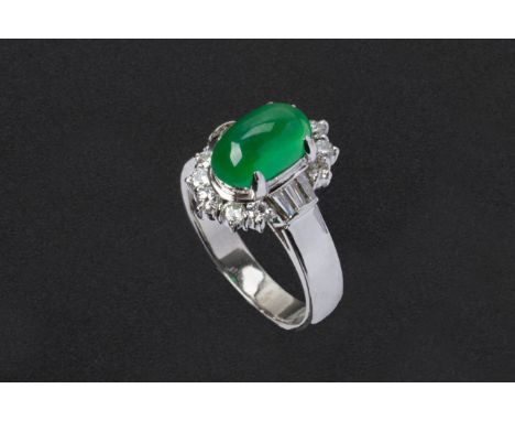 A JADE AND DIAMOND RING
Set in platinum, the cabochon jade with a border of round brilliant cut diamonds 
The jade weighing 2